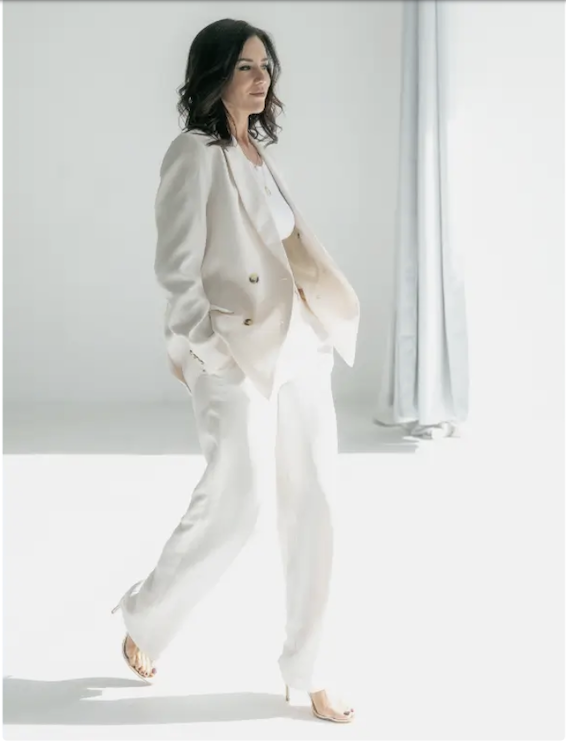Samantha walking in a white suit